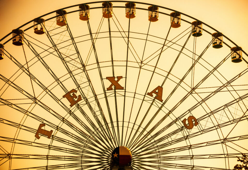 The Texas Star ferris wheel at Fair Park in Dallas, silhouetted against a golden sky